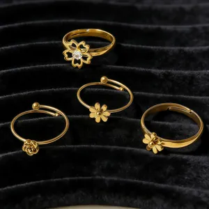 Ensemble de bagues dorées à motif fleurs marguerite et rose sur velours noir élégant