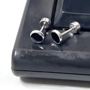 Macro detail of silver titanium steel screw back earrings with black enamel round inlay