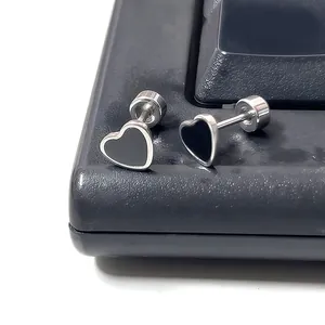 Macro detail of heart-shaped titanium steel earrings with black enamel and screw-back closure