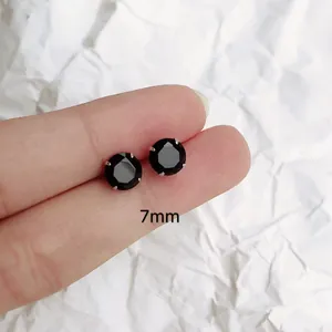 Vista macro detallada de pendientes de cristal negro de 7mm con engaste clásico de garras