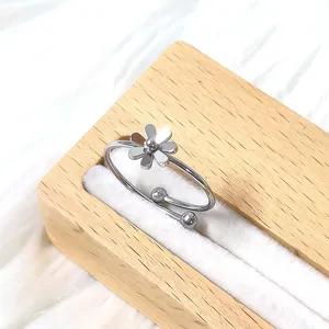 Détail de bague marguerite argentée ajustable sur support en peluche blanche douce