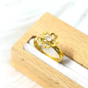 Macro d'une bague fleur dorée réglable avec cristal étincelant dans une boîte à bijoux en bois