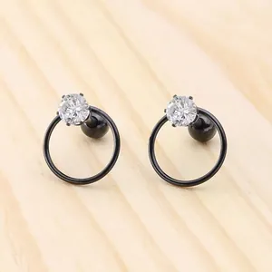 Detail of star zircon earrings with black hoop and secure screw-back ball closure