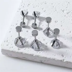 Détail de six boucles d'oreilles en acier inoxydable avec zircons sur pierre blanche