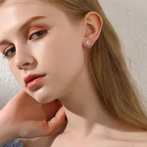 Gros plan de boucles d'oreilles minimalistes en zircone avec serti griffes classique