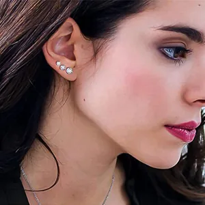 Trois tailles de boucles d'oreilles en zircone étincelantes portées en dégradé sur l'oreille