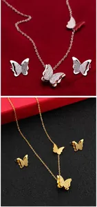 Detalle del conjunto de collar y pendientes de mariposa esmerilada de doble capa en oro