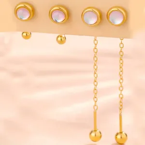 Macro detail of gold-plated flower earrings with opal stones and elegant tassel chains