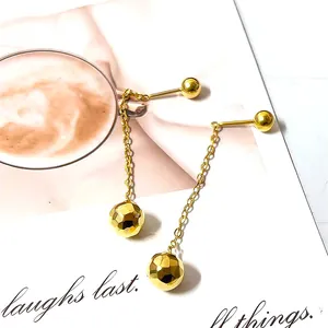 Detail of golden tassel earrings with faceted spheres on a stylish lifestyle background