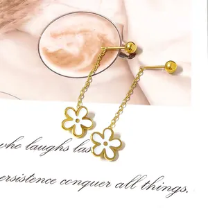 Macro detail of gold-plated chain earrings featuring white daisy pendants and stud balls