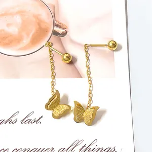 Detail of elegant gold butterfly tassel earrings on a decorative white card