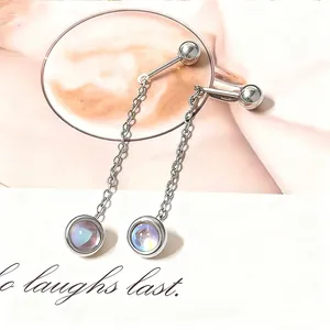 Detailed view of silver tassel earrings with iridescent stones on a soft background