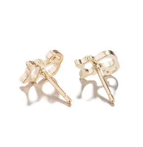 Gros plan de boucles d'oreilles dorées avec un design tendance de double G entrelacé