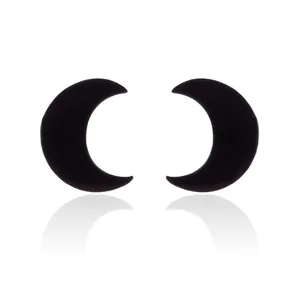 Detailed close-up of a pair of minimalist black crescent moon stud earrings on white background