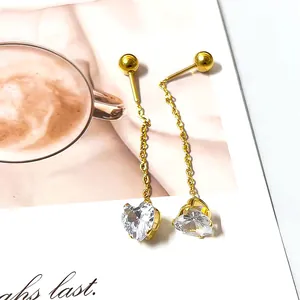 Detail of elegant gold tassel earrings featuring clear heart-shaped cubic zirconia stones