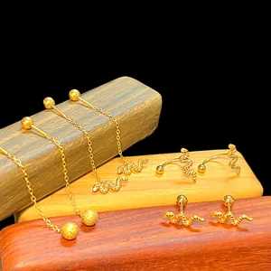 Elegant gold snake earrings and chain studs set displayed on premium wooden stand