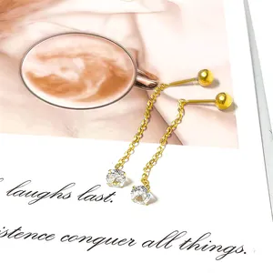 Macro detail of gold tassel earrings with zircon pendant on a vintage magazine page