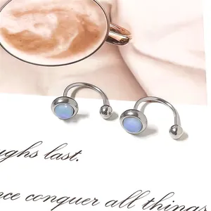 Close-up of silver horseshoe rings with blue opal stones and latte art background