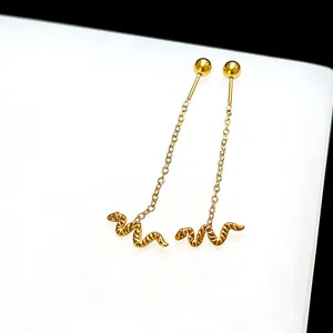 Detail of gold snake earrings featuring delicate chains and textured serpent pendants