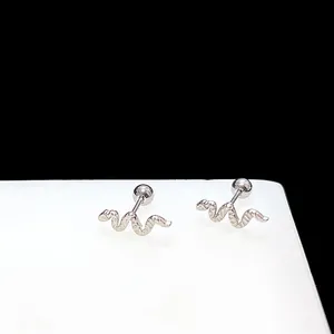 Detailed close-up of snake-shaped silver steel ear studs with textured scales and screw ball back
