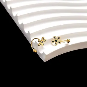 Close-up van gouden madeliefje oorbellen met zwart email op een gegolfde display