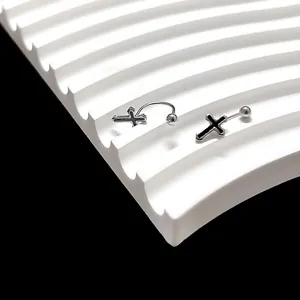 Detail van zilveren U-vormige schroefoorbellen met zwart kruis en hartolie-ontwerp