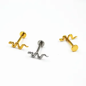Detailopname van drie slang labret piercings in goud en zilver van chirurgisch staal