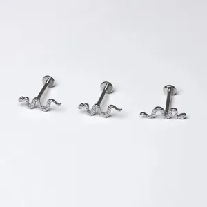 Macro-opname van drie zilveren titanium lipstuds in de vorm van een slang met schubtextuur