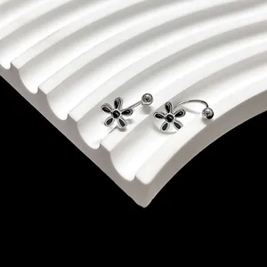 Detail van zilveren piercing sieraden met zwarte madeliefjes op een witte displaystand