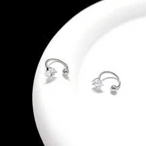 Detailed view of silver U-shaped earrings with square cut zircon on white plate