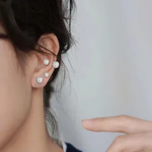 Detailed view of silver titanium steel earrings with pave-set sparkling zircon balls
