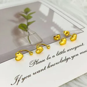 Detalle de los pendientes de corazón dorados y broches en U en tarjeta de presentación