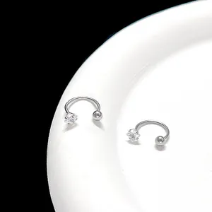 Macro shot of silver horseshoe body piercing with star-cut cubic zirconia and metal ball