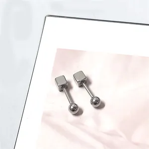 Detail van zilveren titanium stalen oorbellen met een geometrisch kubus- en bolontwerp