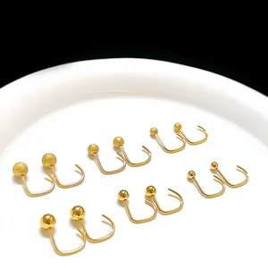 Detail van gouden U-vormige kralen oorbellen met matte en gepolijste afwerking op schaal