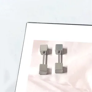 Close-up van geometrische vierkante schroefoorbellen van gepolijst zilver titanium staal