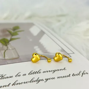 Detalle de pendientes de corazón de oro pulido sobre una tarjeta decorativa