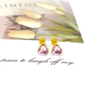 Détail de boucles d'oreilles cœur en zircon rose avec fermoir à vis doré sur carte