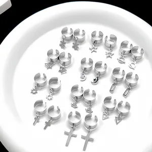 Ohrklemmen-Set aus Edelstahl in Silber mit Kreuz- und Sternanhängern auf Tablett