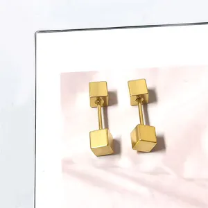 Macro-detail van gouden geometrische vierkante barbell oorbellen met geborsteld metaal