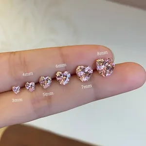 Comparaison détaillée de zircons roses en forme de cœur de 3mm à 8mm tenus sur le bout du doigt