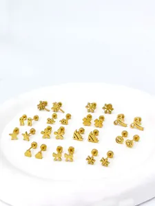 Makroansicht goldener Titanstahl-Ohrstecker mit Stern- und Herzmotiven in Matt
