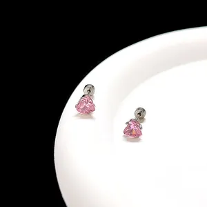 Gros plan sur des boucles d'oreilles cœur rose en zircon avec sertissage en argent