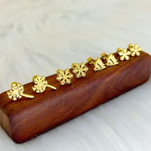 Ohrstecker-Set aus mattem Titanstahl mit Kleeblatt- und Blumenmotiven auf Holz