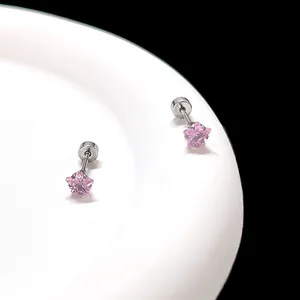 Détail de boucles d'oreilles étoile en zircon rose avec fermoir à vis plat sur assiette