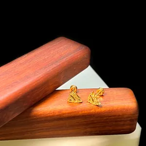 Makroaufnahme von Gold-Segelboot-Ohrsteckern mit Sandstrahl-Finish und Schraubverschluss