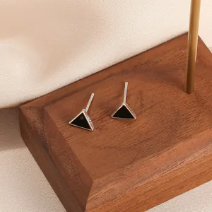 Macro shot of S925 sterling silver stamp on minimalist black triangle stud earrings