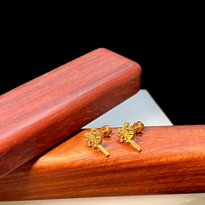 Detaillierte Nahaufnahme goldener Schneeflocken-Ohrstecker mit Schraubverschluss