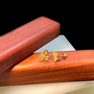 Makro-Detail des goldenen Schneeflocken-Ohrsteckers mit sicherem Titanstahl-Schraubverschluss