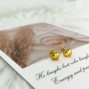 Detalle de pendientes de corazón dorado con cierre de rosca sobre fondo de estilo de vida